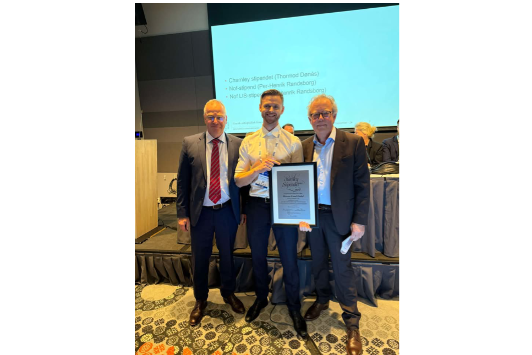 En gruppe menn med et diplom