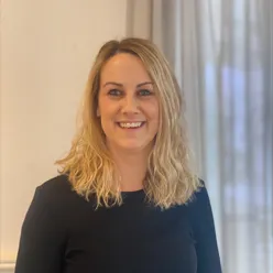 En kvinne som smiler til kameraet