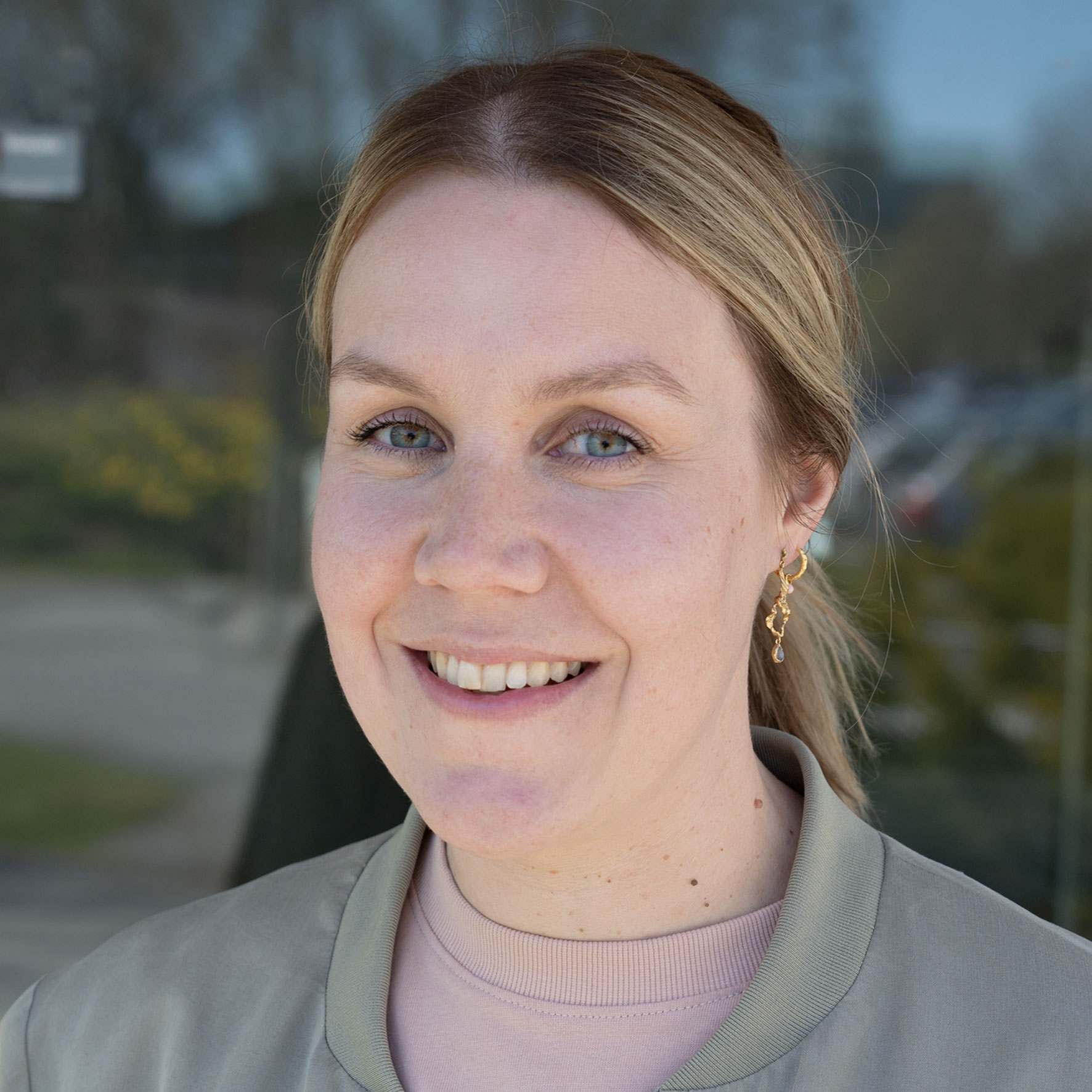 En kvinne som smiler til kameraet