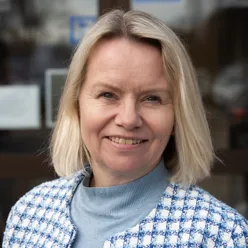 En kvinne som smiler til kameraet