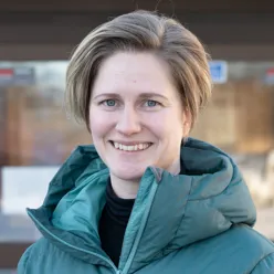 En kvinne som smiler til kameraet