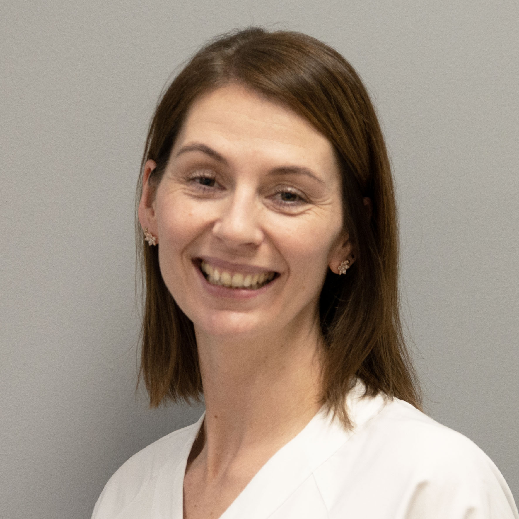 En kvinne som smiler til kameraet