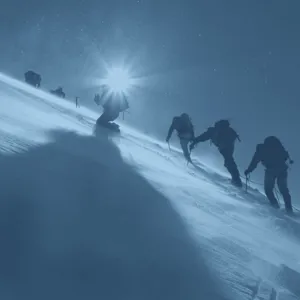 A group of people hiking up a snowy mountain