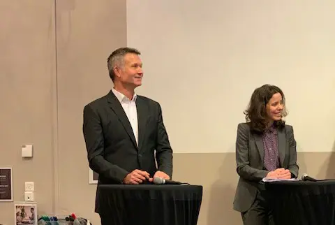 En mann og en kvinne som står ved hver sin talerstol