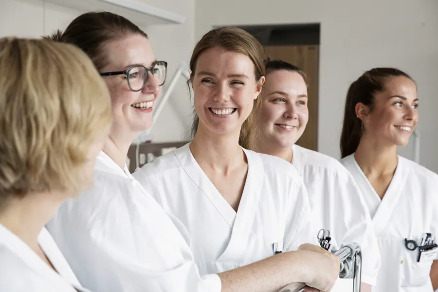 Nært bilde av flire smilande tilsette i sjukehusmiljø