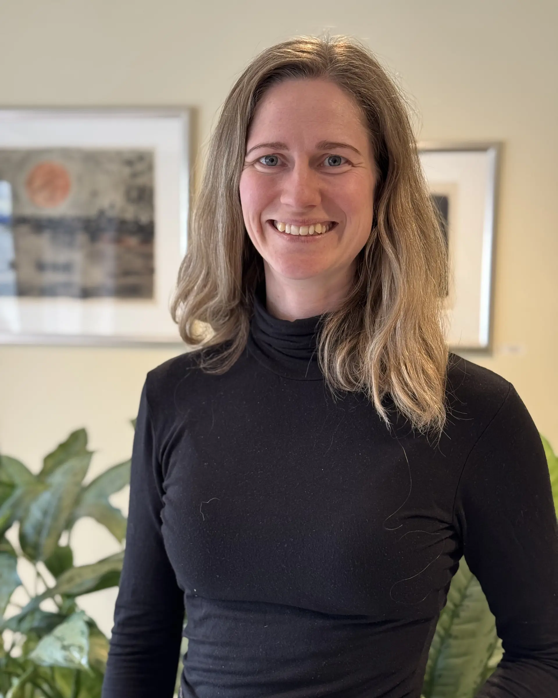 En kvinne som smiler til kameraet